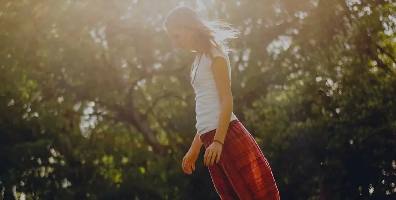 A woman walking through a sunlit field
